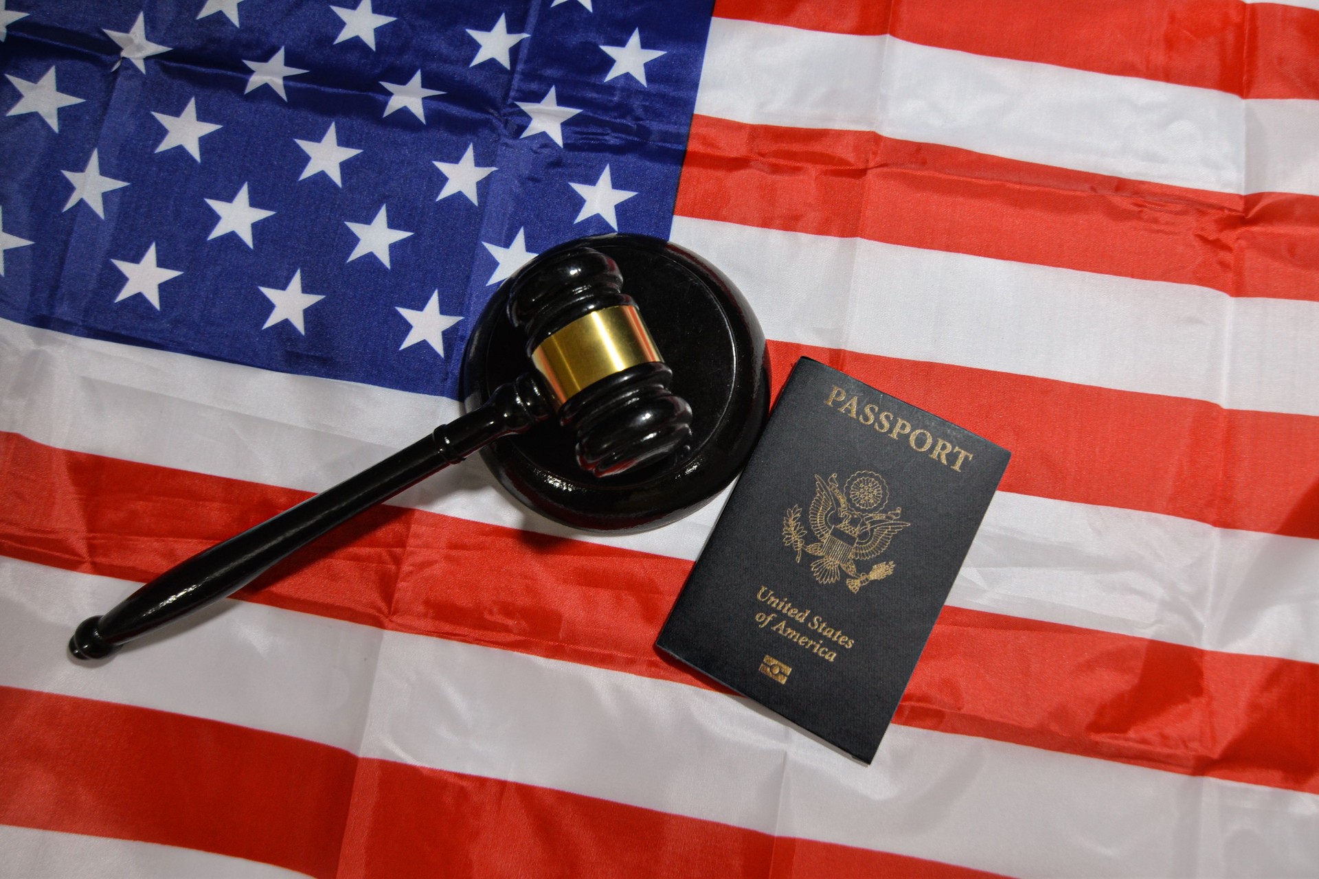 American passport with Court gavel and flag in the backdrop, United States residence and traveling concept background. Citizenship, immigration